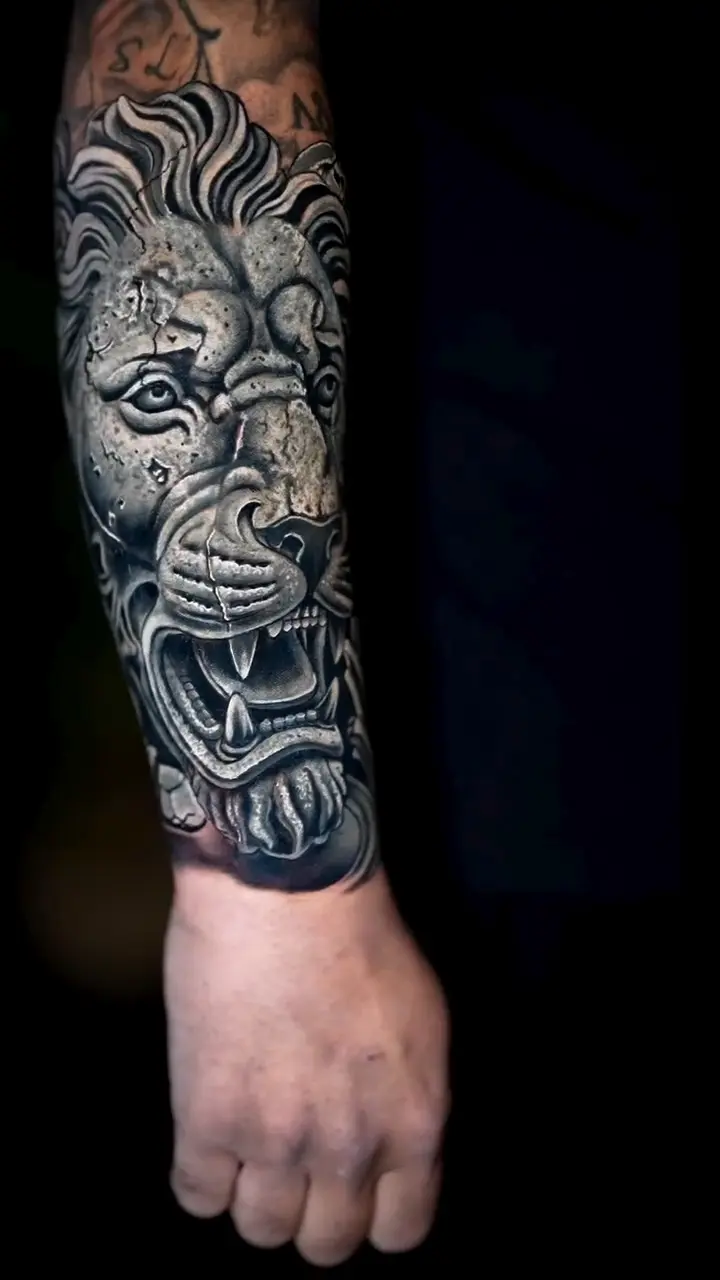 Cover-up de tout un avant-bras : lion en pierre en noir et gris