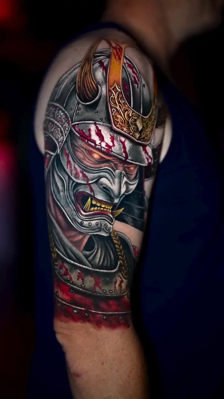 Cover-up sur l’épaule : un ancien tribal recouvert par un samouraï en couleur